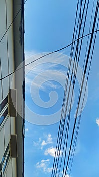 Buildings and electric cables on a blue sky background