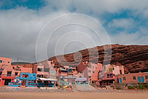 Buildings of hotels, cafes, restaurants, accommodation, and other rentals along Legzira Beach. Rugged coastline in Tiznit Province