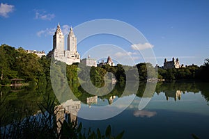 Buildings of Manhattan reflect on calmly water at Central Park with blue sky in summer