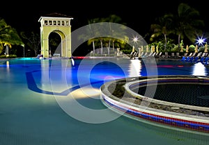 Buildings with night illumination behind pool