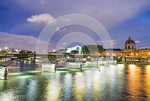 Buildings of Paris around Louvre complex with Seine river at night, France