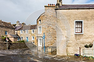 Buildings in Stromness, Orkney in Scotland with a cloudy gray sky in the background