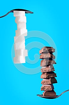 Buildings from sugar cubes and chocololate on a blue background