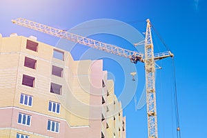 Buildings under construction and cranes under a blue sky. Bright Sunny day, construction of high-rise buildings