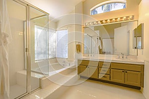 Built in bathtub and shower with glass door inside a beautiful bathroom