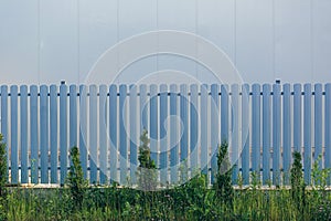 Built-in metal fence, gray and dark color photo from the street