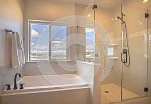 Built in square bathtub inside a bathroom with white wall and sliding window