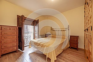 with a built-in wardrobe door with Castilian-style paneled pine doors, a balcony with wooden shutters and light wooden