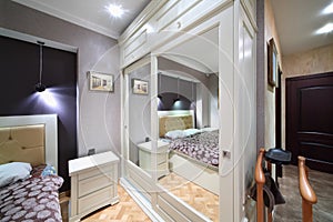 Built-in white wardrobe with mirrored doors in bedroom