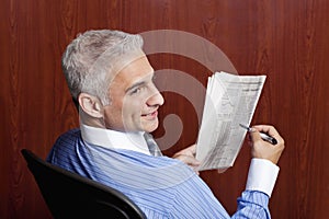 Buinsessman Reading Newspaper with stock quotes
