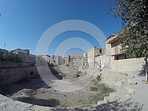 Bukhara. A dry old drinking pond and buildings around,