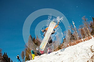 Bukovel, Ukraine - December 22, 2016: Man boarder jumping on his snowboard against the backdrop of mountains, hills and