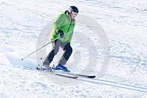 An elderly man skiing down the snowy slope