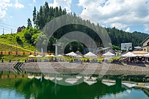 Bukovel. Ukraine. 17. July. 2021. Beautiful fish restaurant by the lake, in a ski resort. Carpathians. Summer rest
