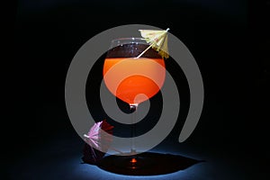 Bulb or time laps of cocktail with umbrellas in pitch black lit with a small flashlight