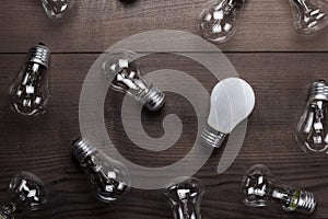 Bulb uniqueness concept on the wooden table photo