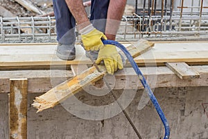 Bulder worker sawing wood board with hand saw