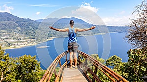 Buleleng - A man standing in a wooden boat on the hill with a lake view