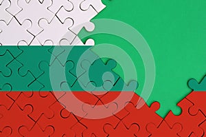Bulgaria flag is depicted on a completed jigsaw puzzle with free green copy space on the right side