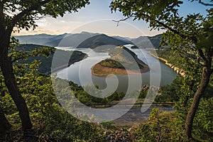 Bulgaria, Kardzhali dam, panoramic view of meander in Arda river, surrounded with green forest, summer time during sunset.