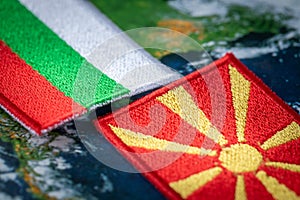 Bulgaria and Macedonia flags patches and country symbols on globe background, Close up, Concept of difficult mutual relations