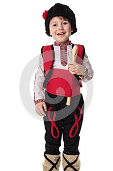 Bulgarian boy in traditional ethnic folklore costume, martenitsa and wooden flute, Bulgaria