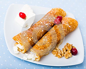 Dish of pancakes palachinki with filling from brynza and walnuts