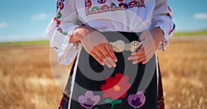 Bulgarian girl wearing traditional ethnic bulgarian costume embroideries and ancient folk belt buckle on wheat field, Bulgaria