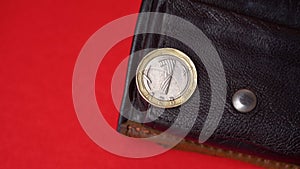 Bulgarian lev coin on red backdrop. Blurred empty wallet in the background. Inflation, money shortage