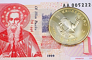 A Bulgarian one lev bank note close up with a gold Krugerrand