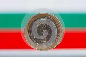 Bulgarian one LEV coin in front of Bulgarian flag