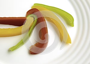 Bulgarian red green yellow pepper slices on white plate