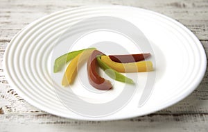 Bulgarian red green yellow pepper slices on white plate