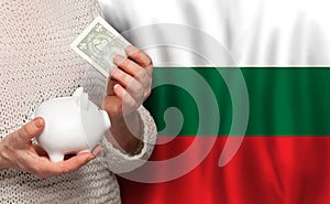 Bulgarian woman with money bank on the background of Bulgary flag. Dotations, pension fund, poverty, wealth, retirement concept