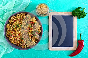 Bulgur with chicken and vegetables. Delicious healthy warm salad on a bright background. Bulgur pilaf.Top view, flat lay.