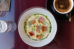 Bulgur porridge with bacon and greenery. Healthy food in restaurant. Modern breakfast not at home