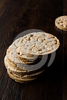 Bulgur Rice Cake Crackers Round Shaped on Dark Wooden Surface.