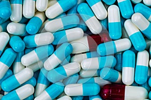 Bulk blue-white and red-white capsule pills. Contaminate in production line of pharmaceutical manufacturing. Drug interaction