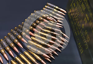 Bulk of bullets of linked ammunition on a black background.