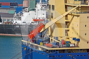 Bulk cargo ship in harbor with pinnace photo