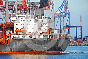 Bulk cargo ship under port crane