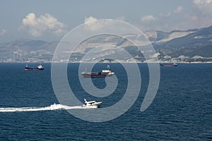 bulk carriers at sea against the backdrop of mountains are waiting for unloading at the port of Novorossiysk.