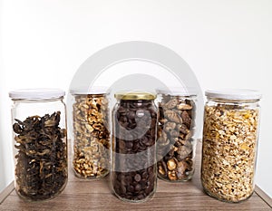 Bulk foods storage in glass jars: dry wild mushrooms, muesli, chocolate and nuts