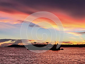 The bulk ship in anchorage, sunset, silhouette