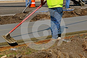 Bull float being used on a freshly poured sidewalk