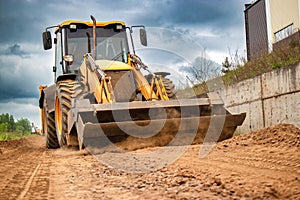 A bulldozer is actively moving dirt on a dirt road. loader