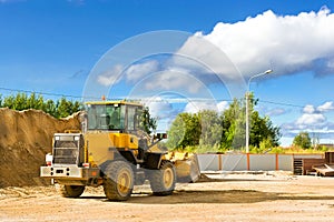 Bulldozer with bucket on construction of road