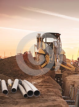 Bulldozer carving hole for pipe laying on constructions site.