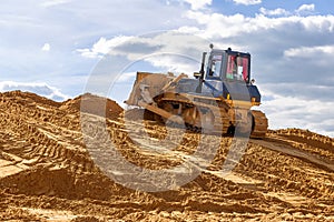 The bulldozer conducts earthworks at the construction site