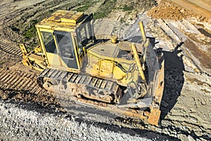 Bulldozer during the construction of a new road. Top view of a powerful working bulldozer. Earthmoving equipment for road works,